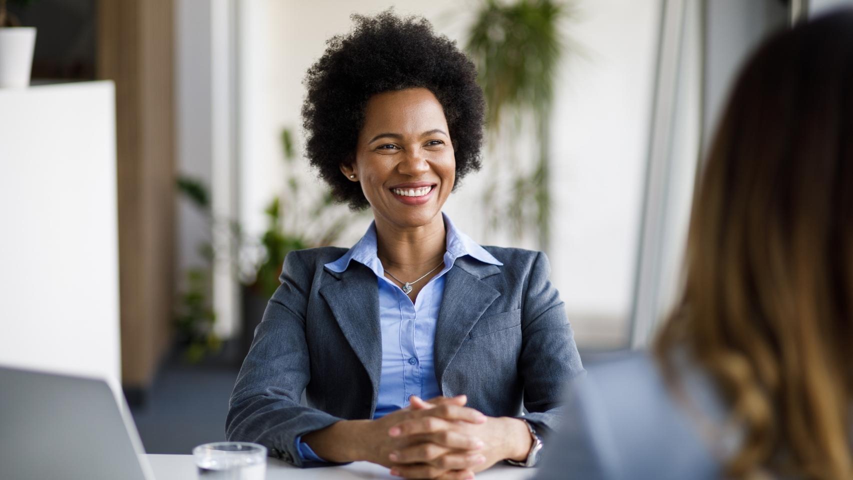 Businesswoman sitting in a chair smiling at the camera