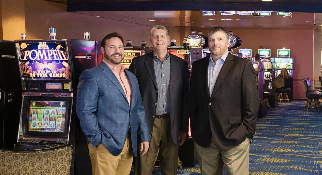 Men in suits standing in a casino, posing for the camera