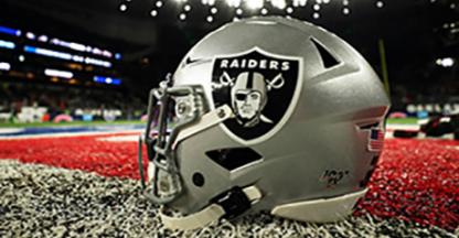 Raiders football helmet sitting on turf