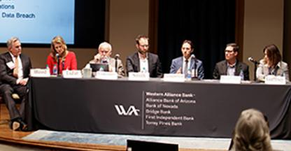 people sitting in a panel on a stage