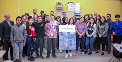 A large group of students pose in the classroom