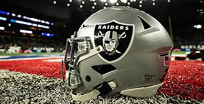 Raiders football helmet sitting on turf