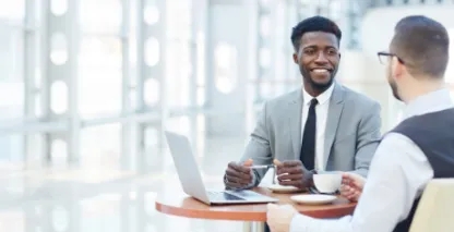 business men enjoying coffee and smiling during meeting