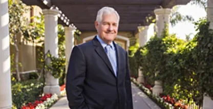 man in a suit standing in a garden