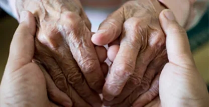 A young pair of hands holding an older pair of hands