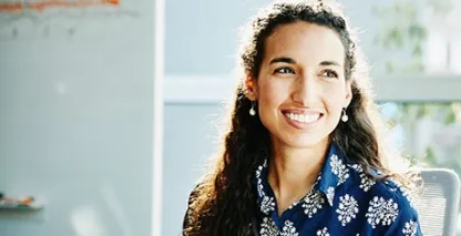 Smiling businesswoman listening to presentation during meeting in conference room