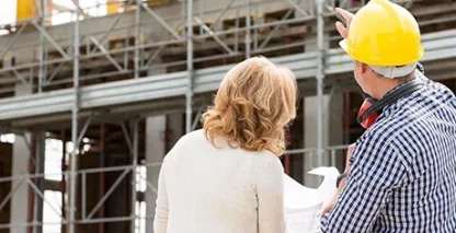 Two people reviewing plans on a construction site