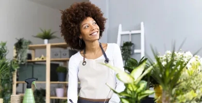 Black woman florist looking at a piece of paper in her shop. 
