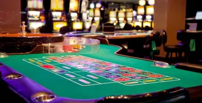 A roulette table and slot machines on a casino floor