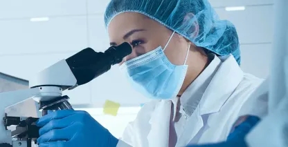 A laboratory technician looking into a microscope