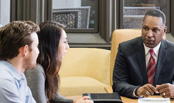 Businessman meeting with a young couple at a conference room table