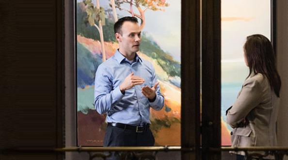 A man and a woman speaking in a office setting