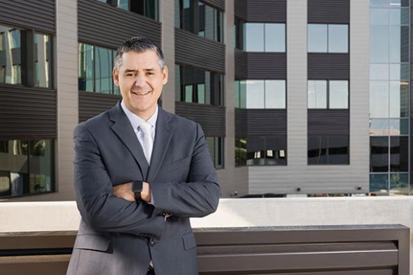 Businessman in a suit with arms folded, smiling at the camera